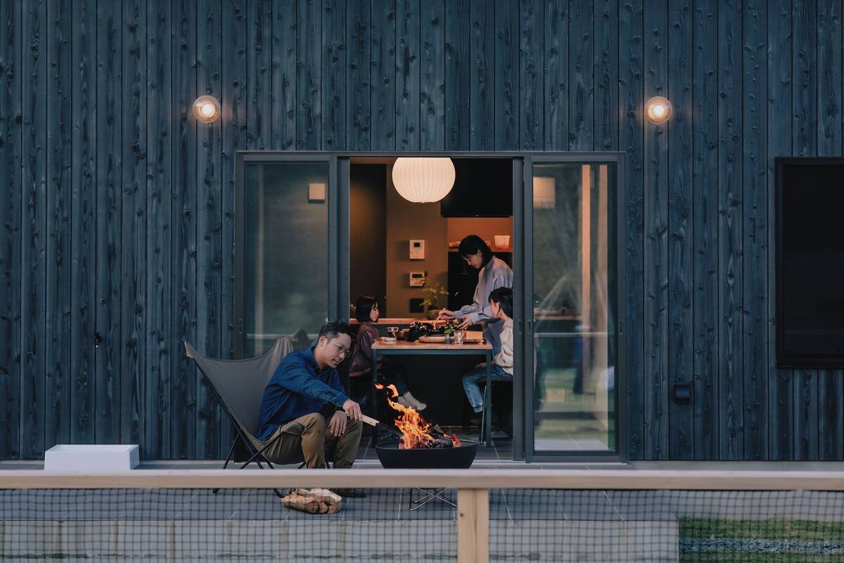 Un espace extérieur moderne aménagé pour les repas, avec un foyer, une table et une chaise.