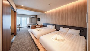 Habitación de hotel con dos camas, un escritorio y una silla.