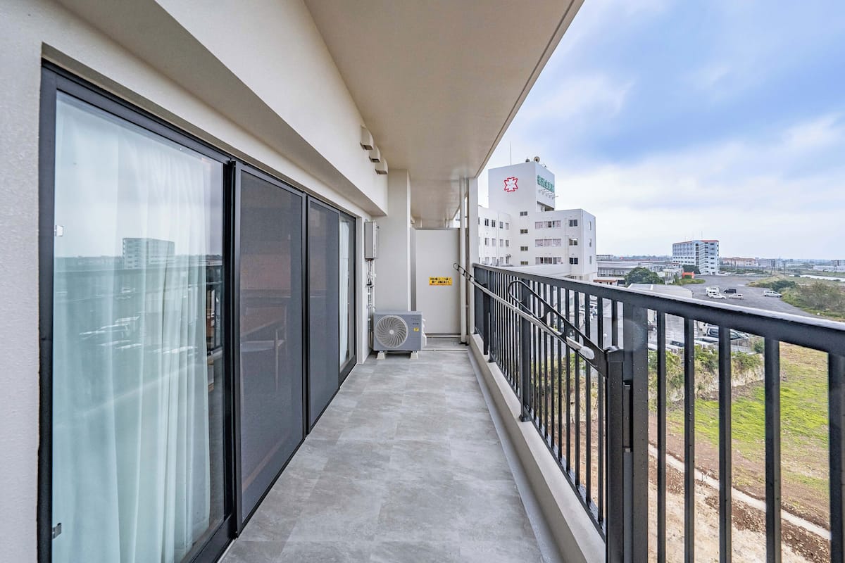 Ein Balkon mit Blick auf Häuser und eine Straße.