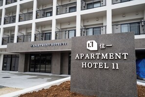 Placa para o Apartment Hotel 11, com um edifício moderno ao fundo.