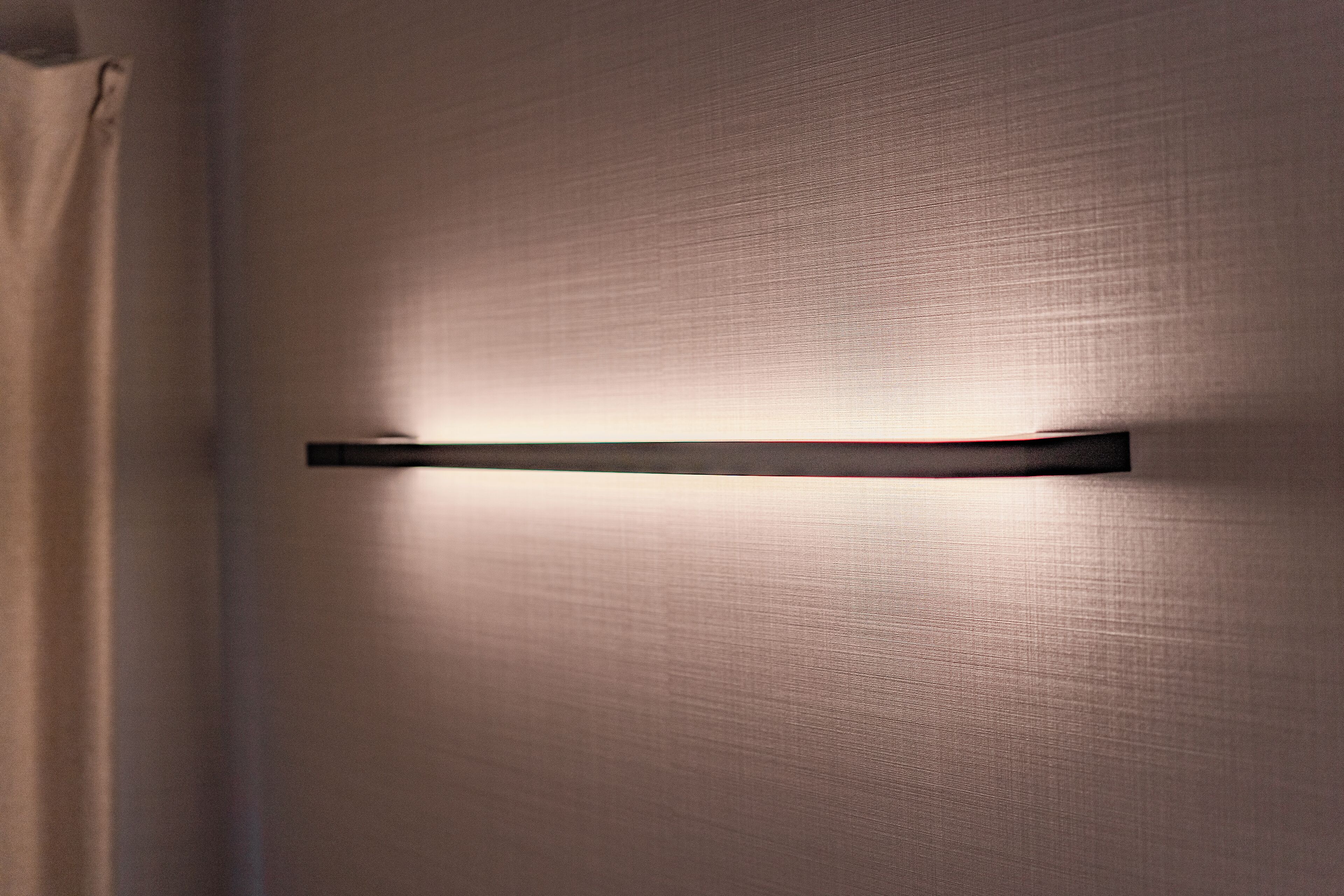 A wall with a horizontal light fixture.