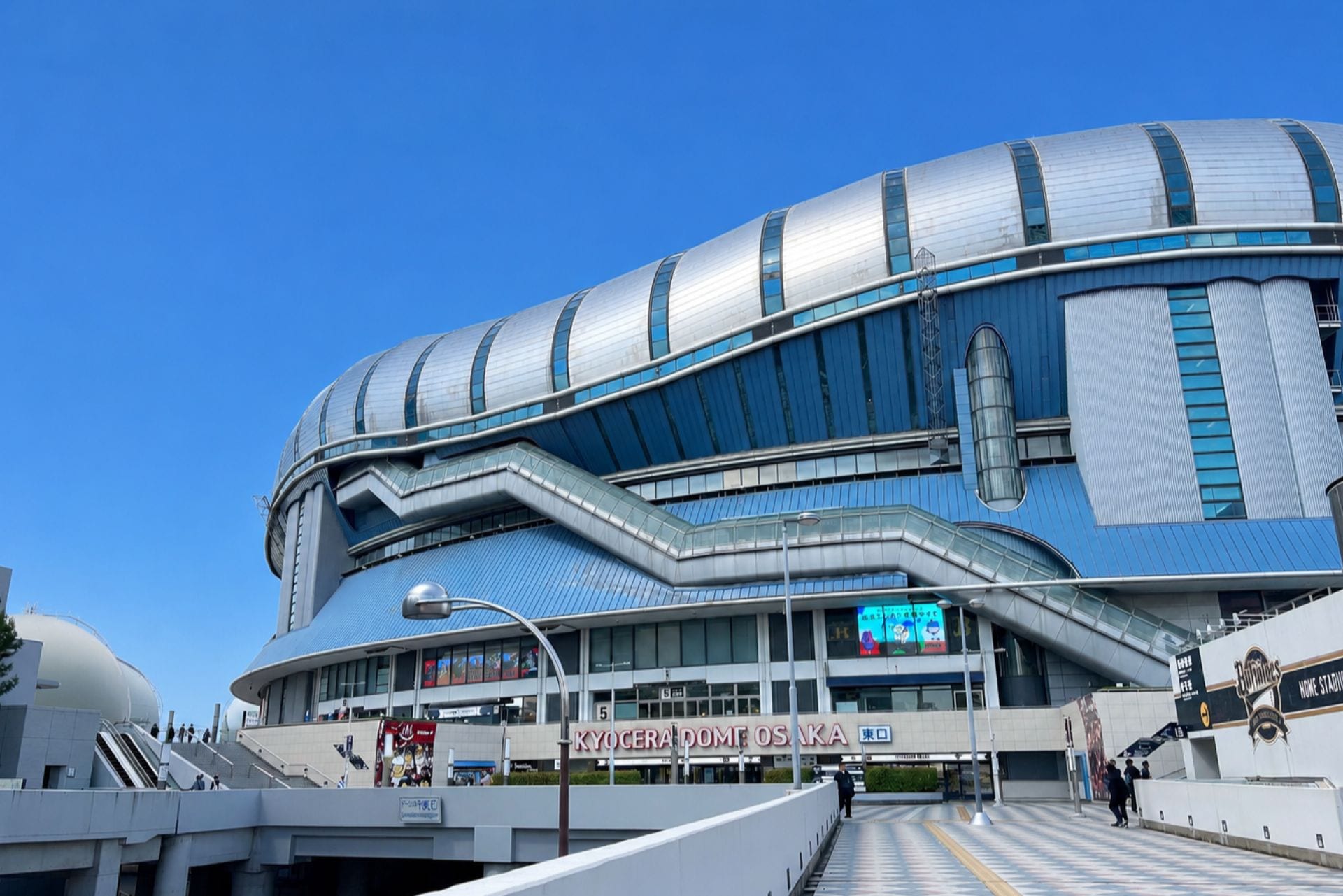 Um estádio moderno com teto curvo e vários níveis de assentos.