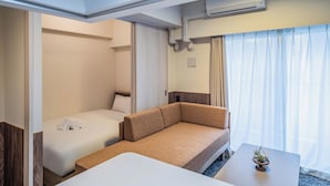 A hotel room with a bed, a sofa, a small table, and a window with curtains. - Apartment Hotel 11 Higashi Umeda (Osaka)