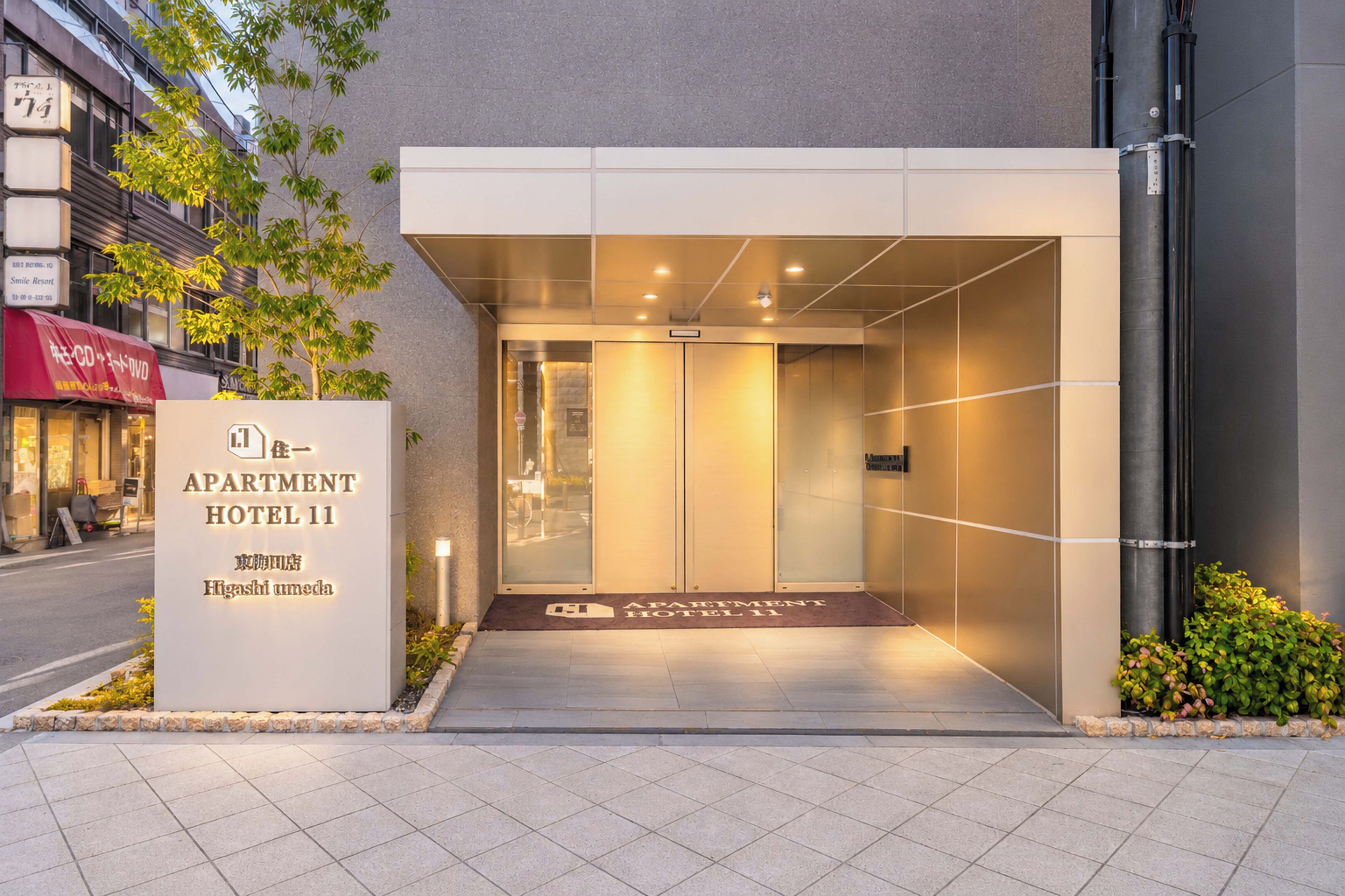 A modern hotel entrance with a sign for 'APARTMENT HOTEL 11'.