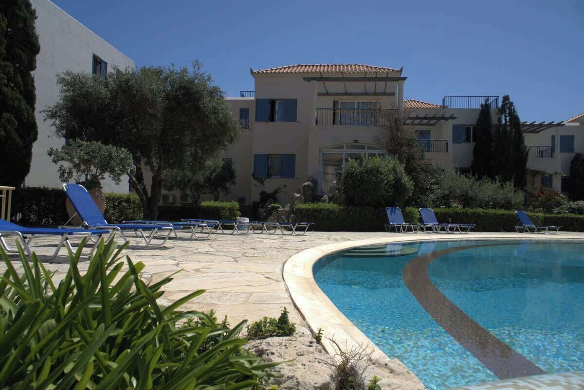 A poolside area with lounge chairs and a clear pool.