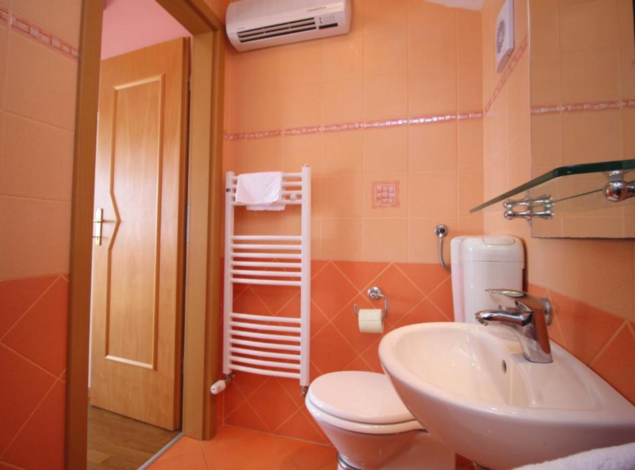 Une salle de bain équipée de toilettes, d’un lavabo et d’un porte-serviettes.