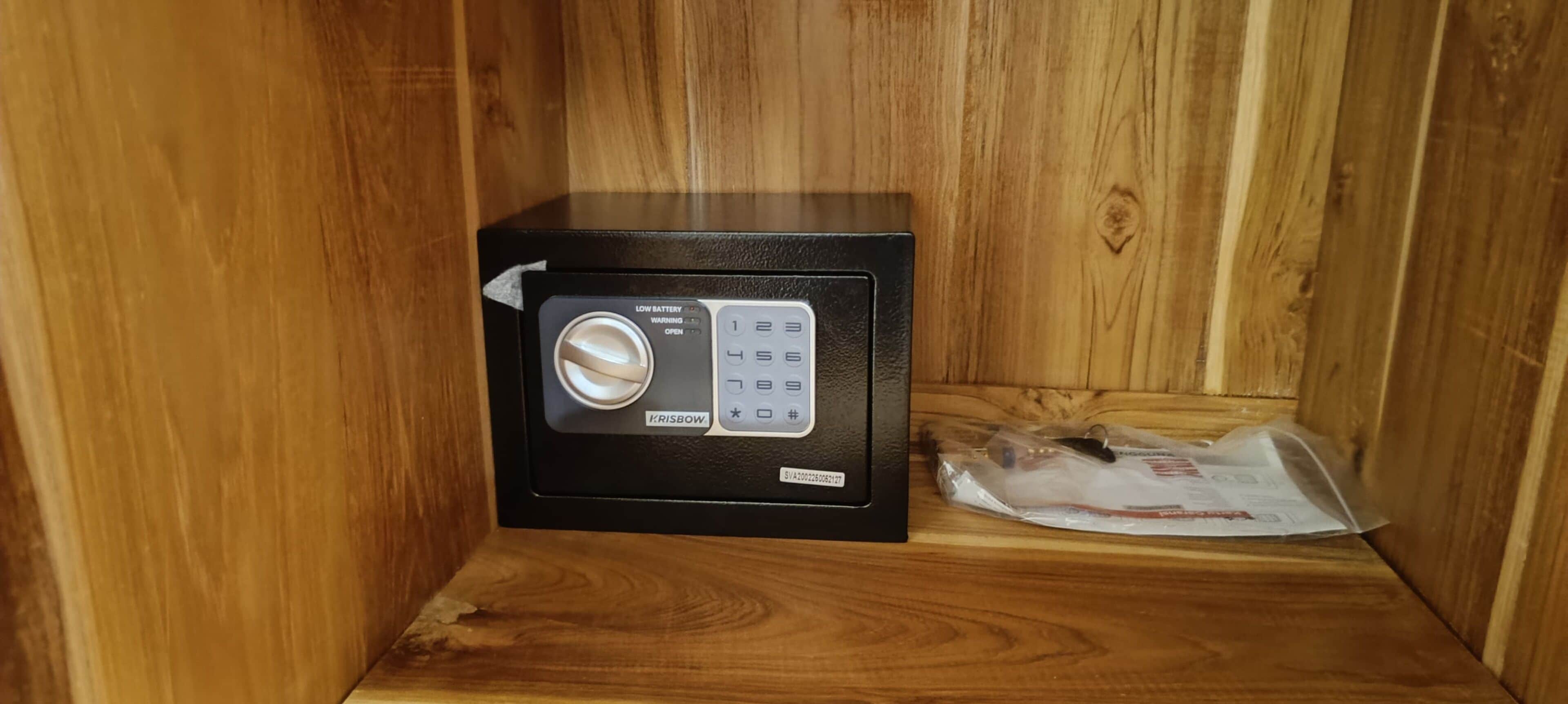 Ein schwarzer Safe mit Tastatur und Schloss auf einem Holzboden.