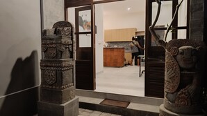 Une porte ornée de sculptures en pierre, un coin cuisine avec des meubles en bois, et une personne prenant une photo.