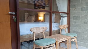 Une pièce avec un cadre en bois, comprenant un lit, deux chaises et une table.