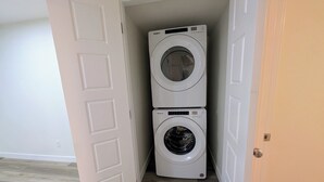 A laundry room with two stacked front-loading washers and dryers. - 2-bedroom Guest Suite in SW Calgary with WiFi (Calgary)