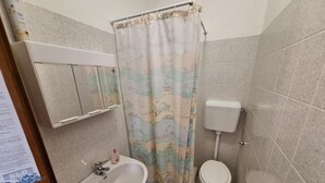 A bathroom with a sink, toilet, and shower curtain.