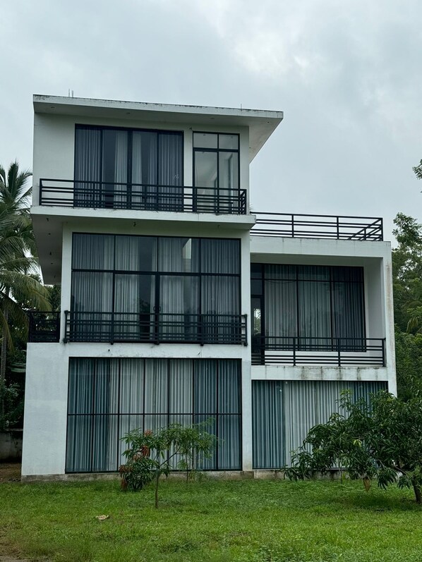 A modern two-story building with large windows and balconies.