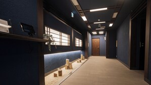 A hotel corridor with a reception desk, a wooden reception desk, a reception area with a counter and chairs, and a door at the end. - ORI Nipponbashi (Osaka)
