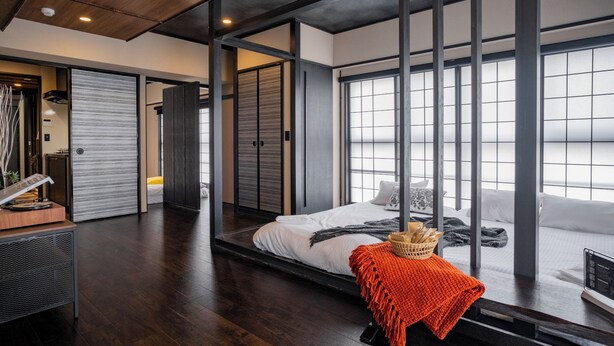 A modern hotel room with a large bed, sliding doors, and a view of the city. - ORI Nipponbashi (Osaka)