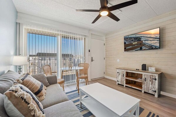 A modern living room with a sofa, a coffee table, a TV, and a wooden cabinet.