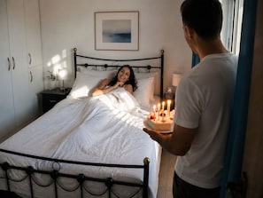 Une chambre à coucher comprenant un lit, une table de chevet, une commode et un tableau accroché au mur.