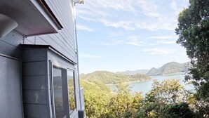 A house with a view of a lake and mountains. - Designer Island Villa with Stunning Panoramic Sea Views (Bizen)