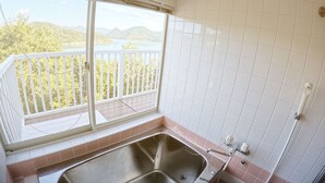 A bathroom with a large window, a sink, and a view of a balcony with a railing. - Designer Island Villa with Stunning Panoramic Sea Views (Bizen)