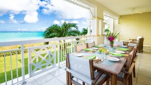 A dining area with a view of the ocean, a white railing, and a table set for four. - 2 BR Oceanfront, All-Inclusive Suite at Alexandra Resort (The Bight Settlement)