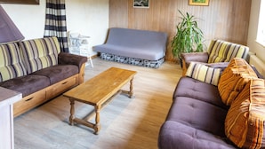 A cozy living room with wooden beams, a sofa set, a coffee table, and a plant. - Gîte 'La Pature', 2 to 6 persons (Le Barboux)