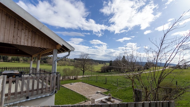 A wooden deck with a view of a grassy field and trees. - Gîte 'La Pature', 2 to 6 persons (Le Barboux)