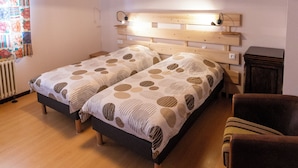 A bedroom with two beds, wooden ceiling, and a small wooden cabinet. - Gîte 'La Pature', 2 to 6 persons (Le Barboux)