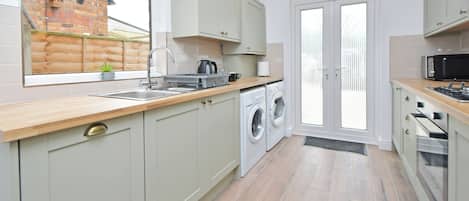 Enjoy cooking in this well-lit kitchen with a stainless steel sink and washing machine.