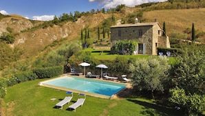 A stone villa with a swimming pool, surrounded by lush greenery and hills. - Casale Rigo in San Casciano dei Bagni (San Casciano dei Bagni)