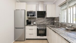 A modern kitchen with a stainless steel refrigerator, built-in microwave, oven, and a marble countertop. - Las Camelias in Chiclana de la Frontera (Chiclana de la Frontera)