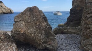 Eine felsige Küstenlandschaft mit einem Boot im Wasser.