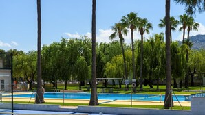 A swimming pool with multiple lanes, surrounded by palm trees and a clear blue sky. - Artesol in Platja de l Arenal (Els Poblets)