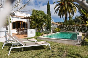 Relax by the serene pool surrounded by lush greenery and comfortable lounge chairs.