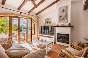 A living room with a TV, fireplace, and outdoor patio.