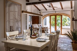 Enjoy meals in this cozy dining area with a table set for four, featuring a white tablecloth and blue and white patterned plates.