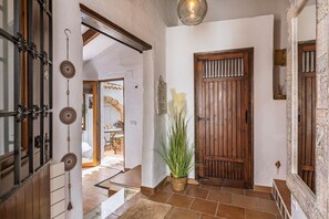 Stroll through this charming hallway, featuring a traditional wooden door and a touch of greenery from a potted plant.