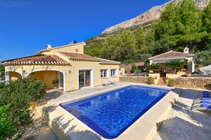 A poolside area with a swimming pool, lounge chairs, and a mountain backdrop. - El Elefante in J vea (Javea)