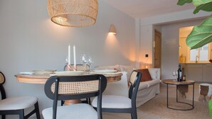 A dining area with a round table, chairs, and a hanging light fixture. - La Casita Bonita in Platja de l Arenal (Javea)