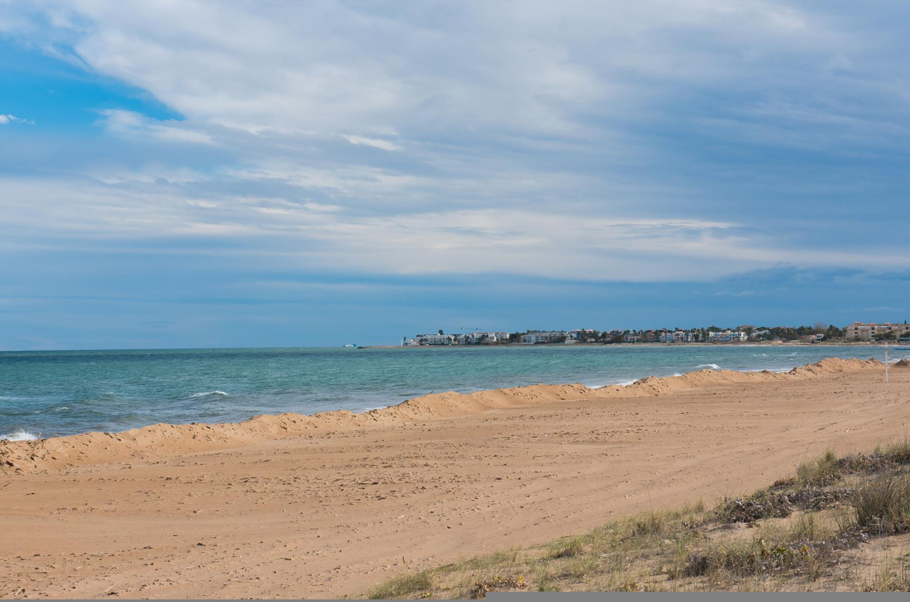 A beach with a clear sky and calm sea.
