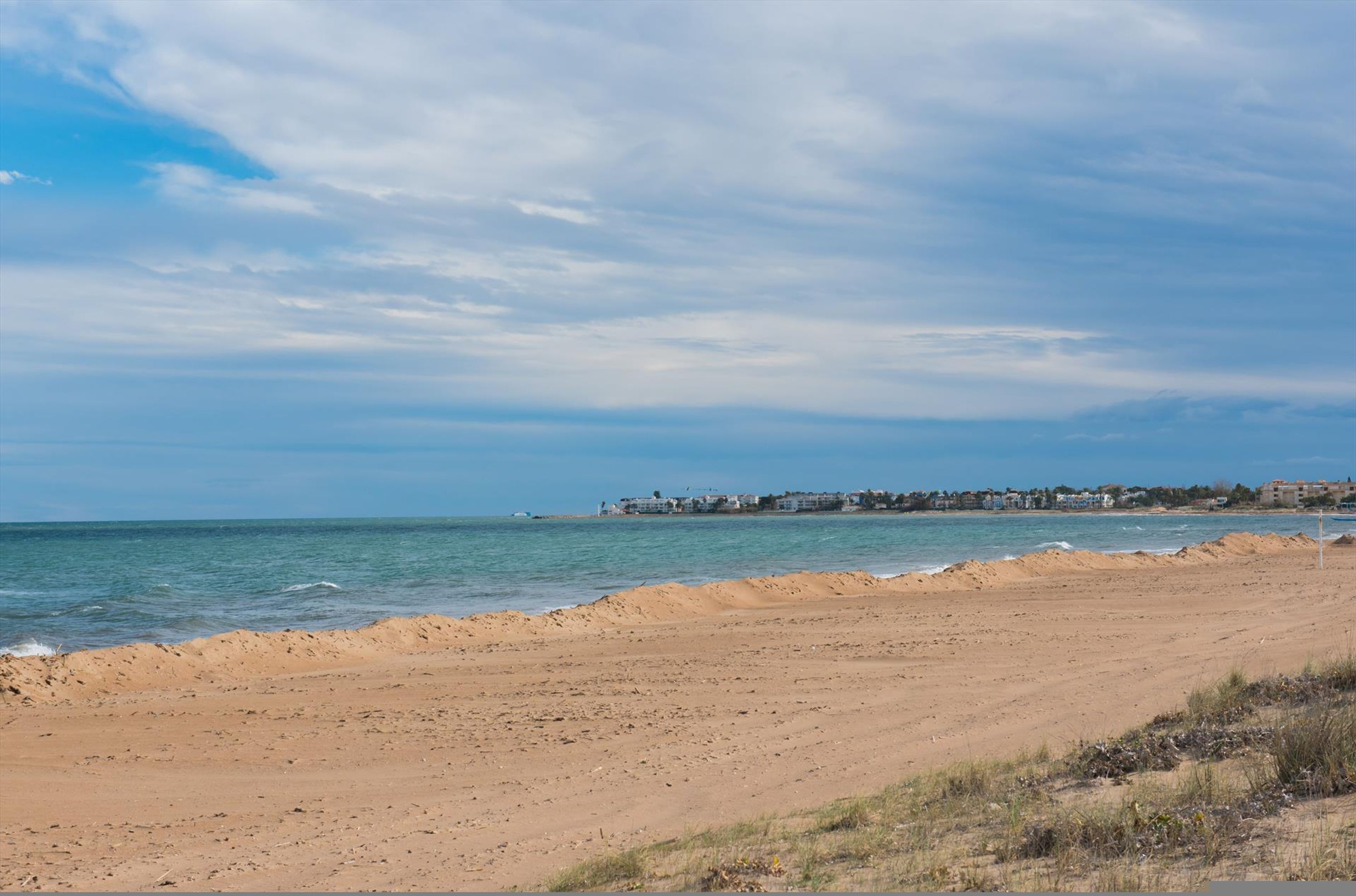 A beach with a clear sky and calm sea.