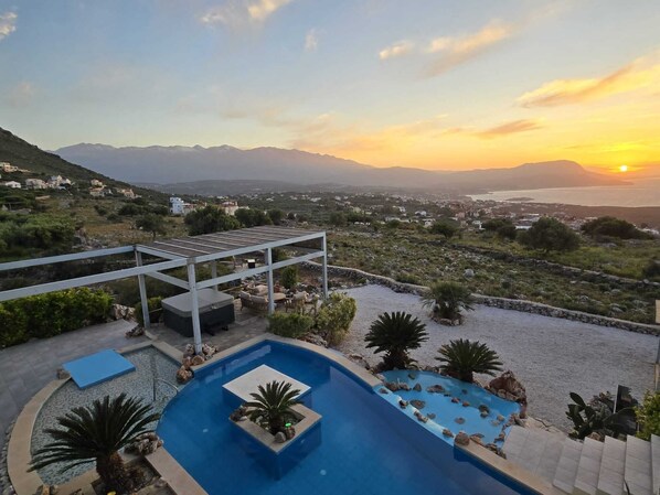 A pool area with a view of the sunset and mountains. - Villa sea view heated pool (Kokkino Chorio)