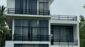 A modern two-story building with large windows and balconies.