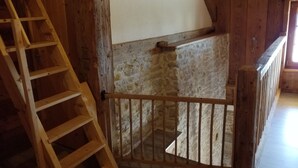 A wooden staircase with a metal gate leading to a stone wall. - Gîte 'Les Ursules', sleeps 2 to 6 (Le Barboux)