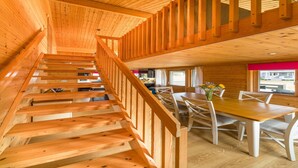 A wooden staircase leading to a dining area with a table and chairs. - Lodge in Caldecott Hall with Private Hot Tub (Fritton)