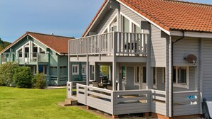 A two-story house with a balcony, a covered porch, and a red-tiled roof. - Lodge in Caldecott Hall with Private Hot Tub (Fritton)