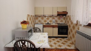 A compact kitchen with a microwave, coffee maker, and oven. - Apartman Štefica with AC and balcony for 2 people (Punat)