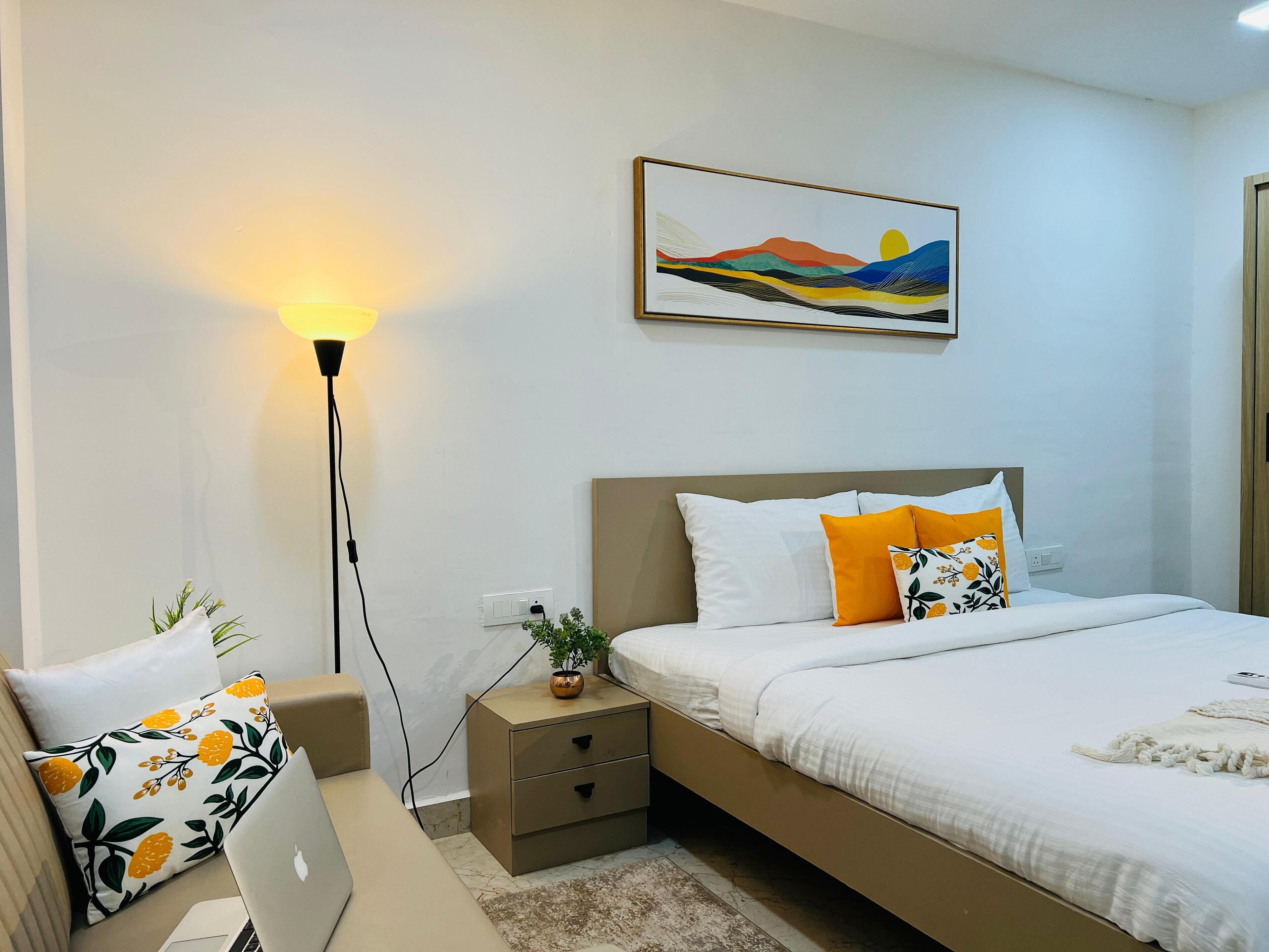 A neatly arranged bedroom with a bed, bedside tables, a lamp, and a painting on the wall.