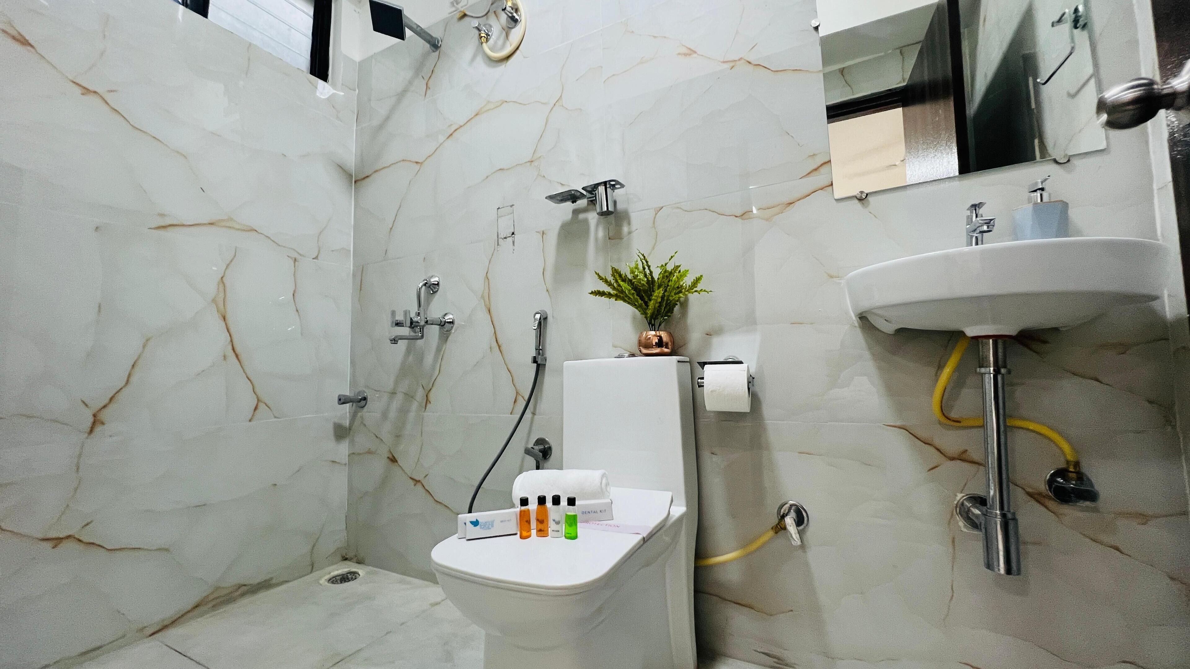 Une salle de bain équipée de toilettes, d’un lavabo et d’une douche.