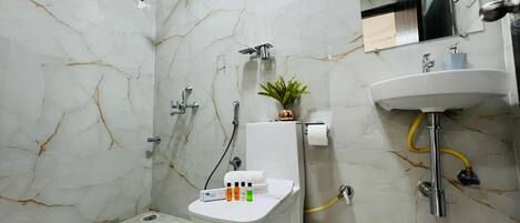 A bathroom with a toilet, sink, and shower.