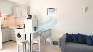 A compact living space with a kitchenette, a dining area, and a sofa. - PRAIA DA ROCHA – CLUB PRAIA DA ROCHA VI (Portimão)