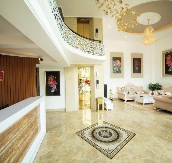 A spacious living area with a high ceiling, a decorative chandelier, and a modern staircase. - MINH CƯƠNG HOTEL (Xuan Huong - Da Lat)